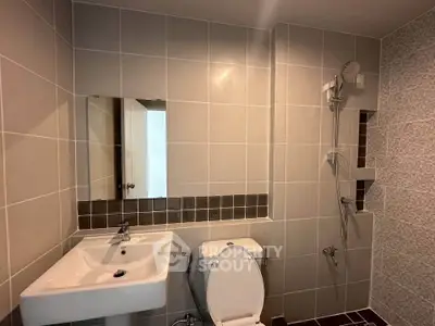 Modern bathroom with sleek tiles and contemporary fixtures.