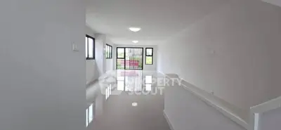 Spacious modern living room with large windows and glossy floors, perfect for natural light lovers.