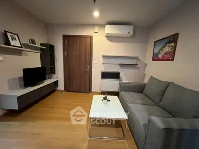 Modern living room with sleek furniture and wall-mounted TV, perfect for urban living.
