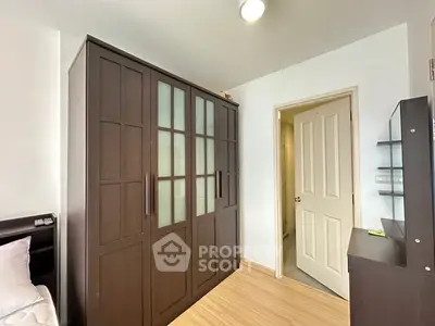Spacious bedroom with elegant dark wood wardrobe and modern decor