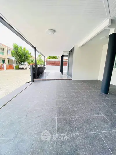 Spacious modern outdoor area with sleek tiled flooring and covered patio, perfect for relaxation and gatherings.