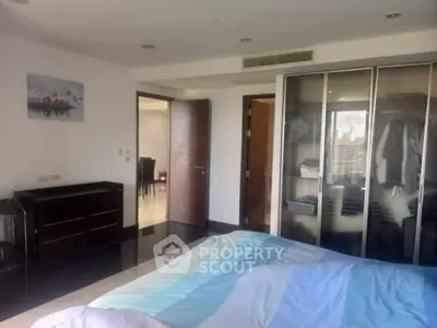 Spacious bedroom with modern closet and stylish decor in a luxury apartment.