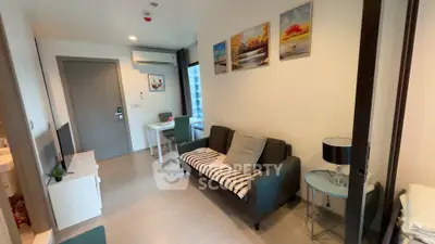 Modern living room with cozy sofa, wall art, and dining area in a stylish apartment.