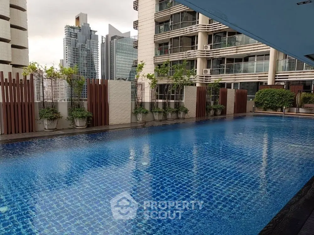 Luxurious rooftop pool with stunning city views in modern high-rise building.