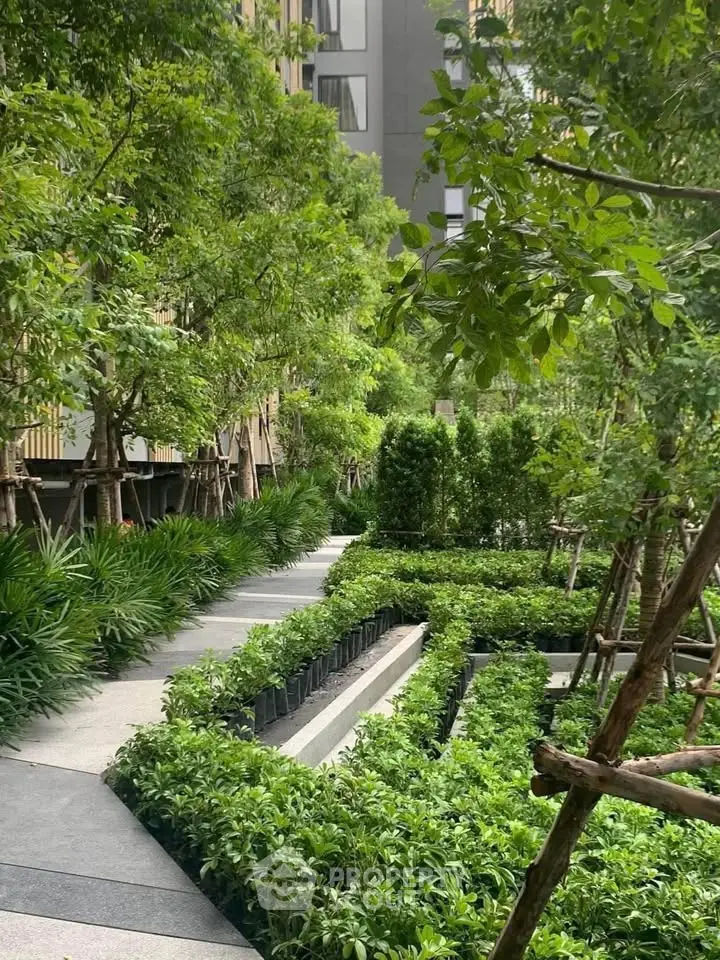 Lush green garden pathway in modern residential complex, offering serene outdoor living.
