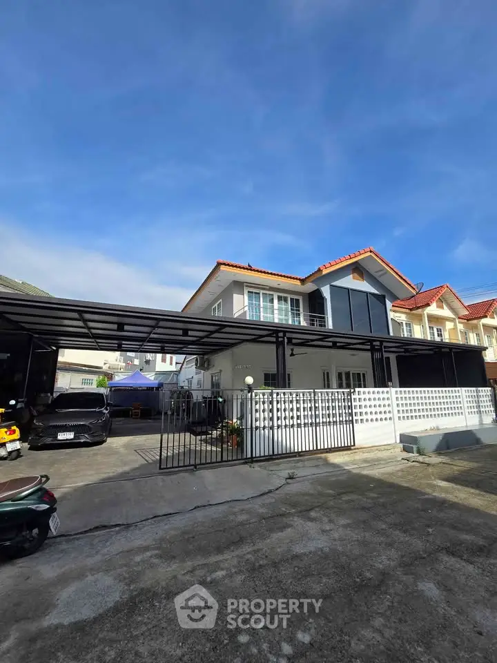 Spacious modern house with large carport and gated driveway in a serene neighborhood.