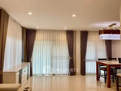 Spacious living room with elegant curtains and modern dining area, perfect for family gatherings.