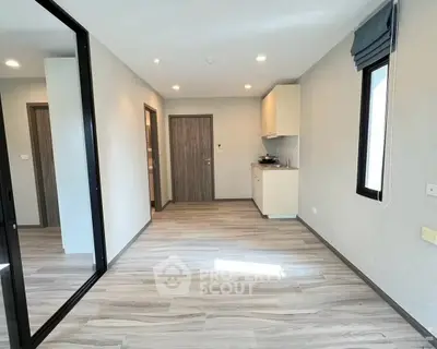 Modern apartment interior with sleek flooring and compact kitchen area, ideal for urban living.