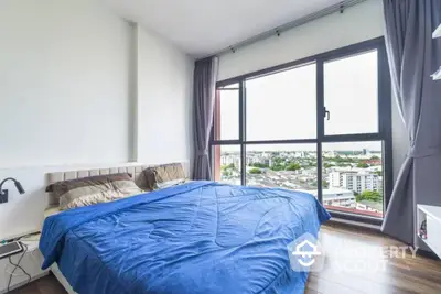 Spacious bedroom with large window offering stunning city view