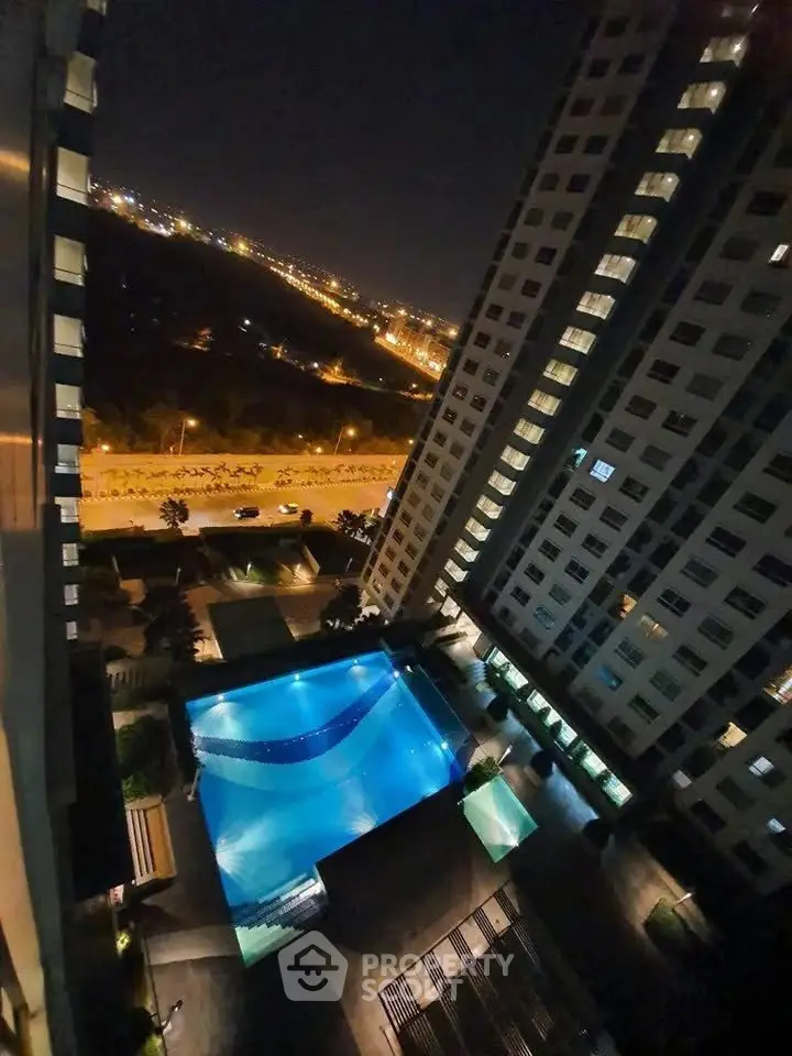 Stunning night view of modern high-rise buildings with illuminated pool area.