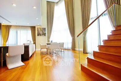 Luxurious open-plan living room with high ceilings and elegant staircase