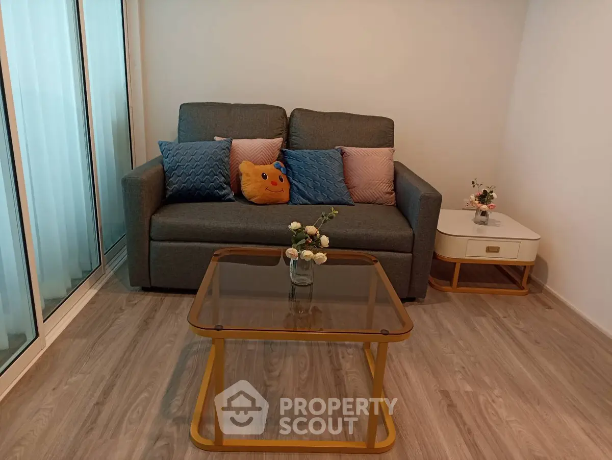 Cozy living room with modern sofa and glass coffee table in stylish apartment