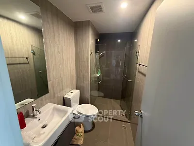 Modern bathroom with glass shower and sleek fixtures in contemporary home.