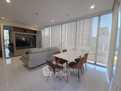 Modern living room with city view, sleek furniture, and natural light.