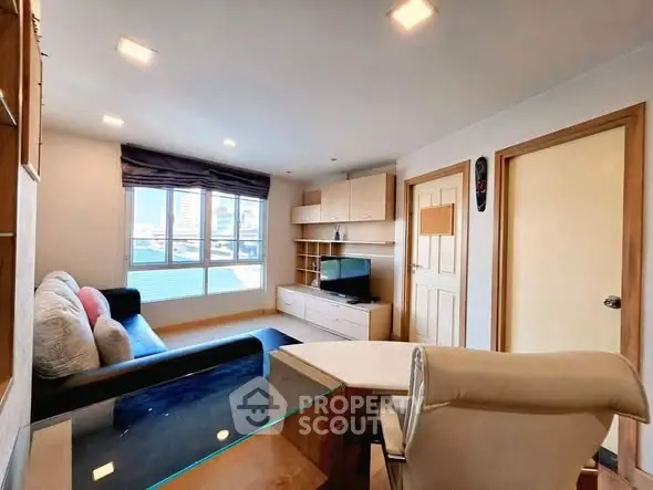 Spacious living room with modern decor and large window offering city views.