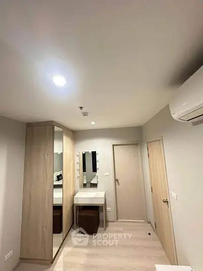 Modern bedroom with built-in wardrobe and vanity in a stylish apartment.
