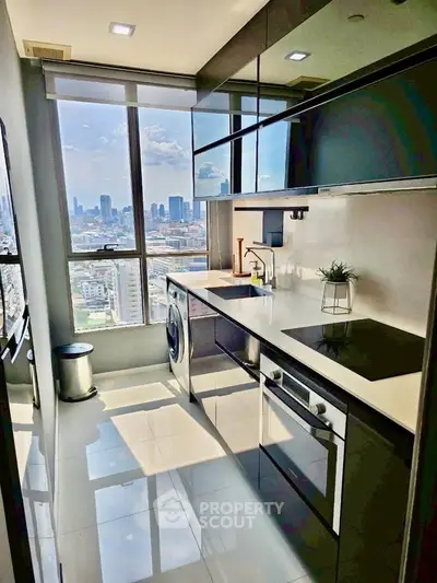 Modern kitchen with stunning city view, sleek appliances, and glossy cabinets in a high-rise apartment.