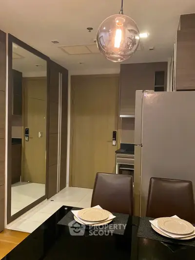 Modern kitchen with sleek design, featuring a dining area and contemporary lighting.