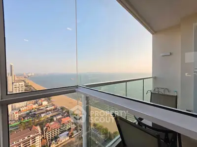 Stunning beachfront balcony with panoramic ocean views in a high-rise apartment.