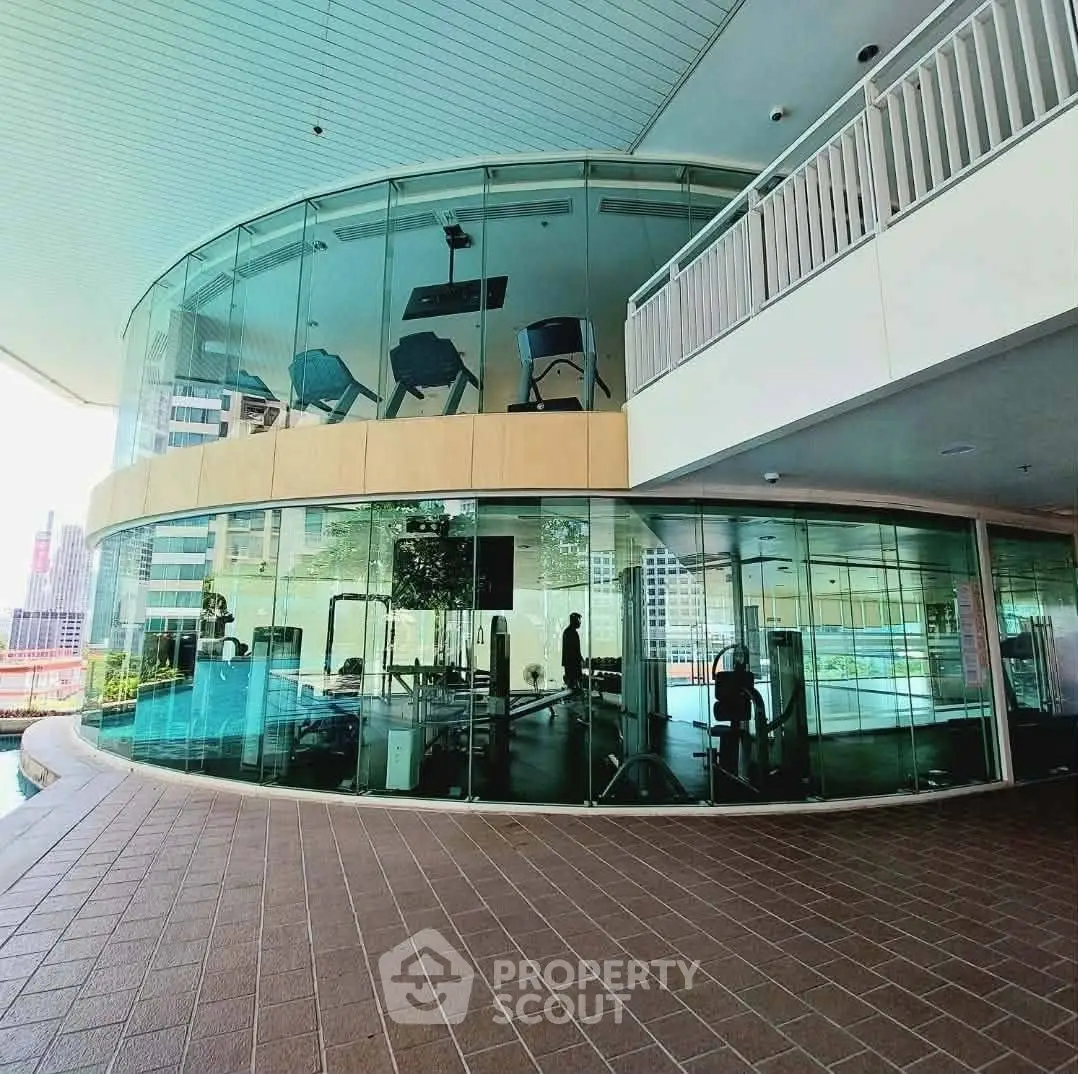 Modern glass-walled gym with city views in luxury residential building