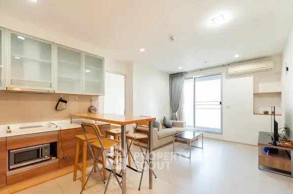 Modern open-plan living room and kitchen with sleek design and natural light.