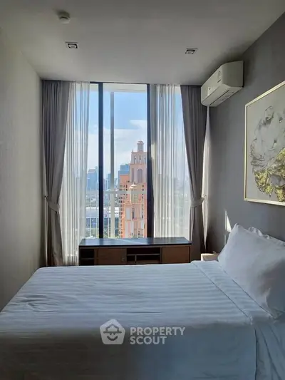 Modern bedroom with large window offering stunning city view