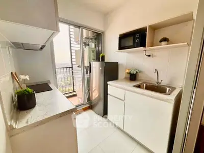 Modern kitchen with sleek design, featuring a compact layout and balcony access, perfect for urban living.