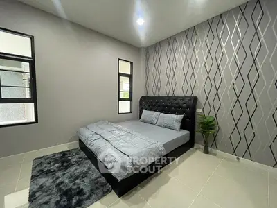 Modern bedroom with stylish wallpaper and sleek black bed frame in a contemporary home.