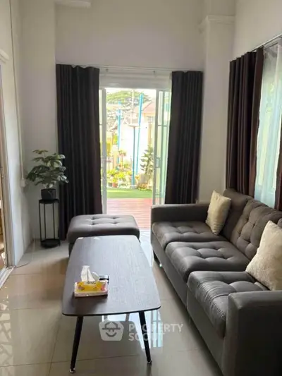 Charming living room with modern sofa and garden view, perfect for relaxation and entertaining guests.