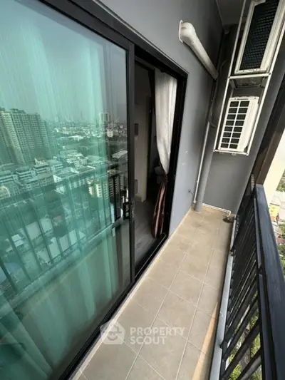 Modern high-rise balcony with city view and sliding glass doors