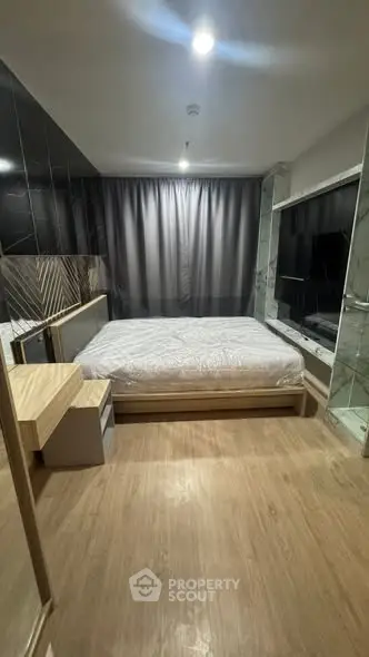 Modern bedroom with sleek design, featuring a large bed, wooden flooring, and stylish decor.