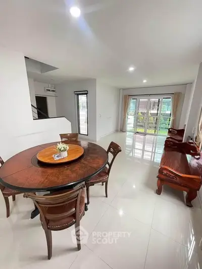 Spacious open-plan living room with elegant wooden furniture and large windows