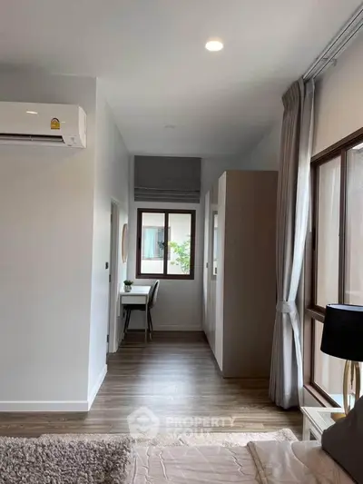Modern bedroom with large window, air conditioning, and stylish decor
