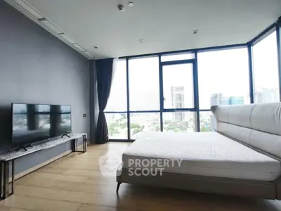 Luxurious bedroom with floor-to-ceiling windows offering stunning city views and modern furnishings.