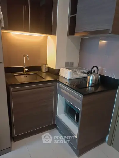 Modern compact kitchen with sleek cabinetry and built-in appliances, perfect for urban living.