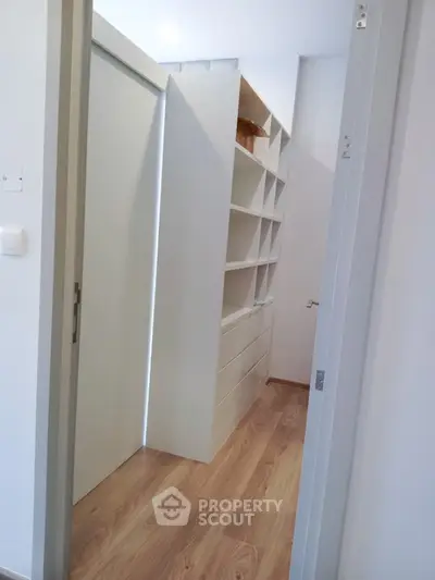 Spacious walk-in closet with modern shelving and wooden flooring