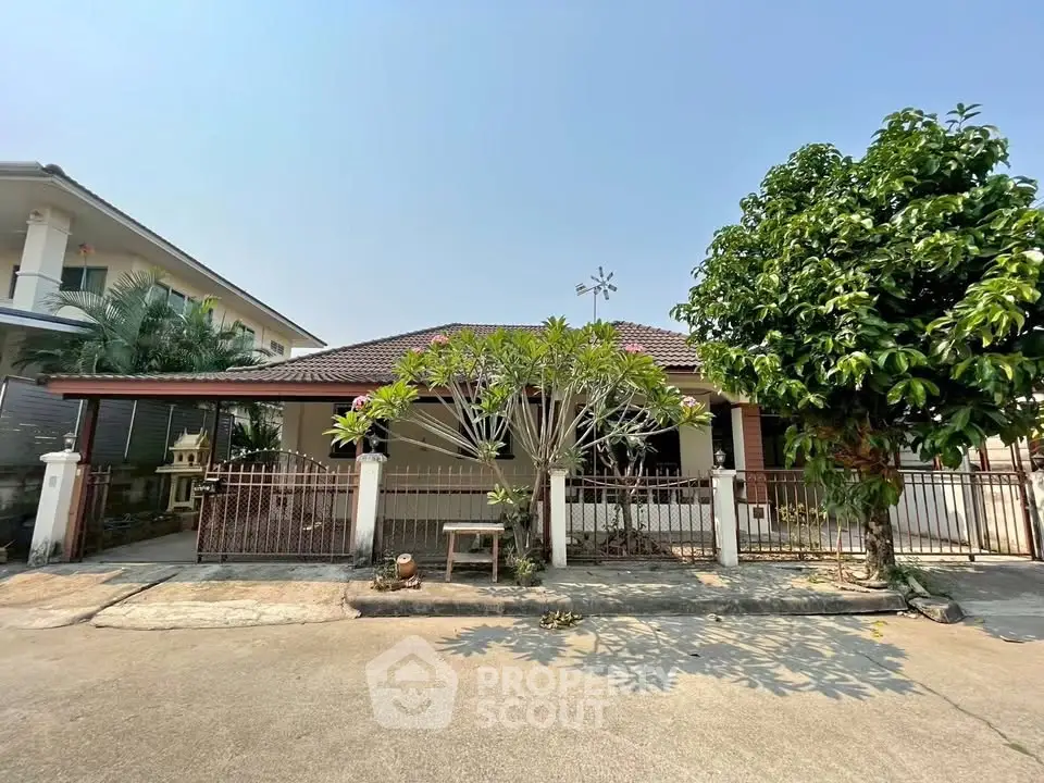 Charming single-story home with a spacious front yard and lush greenery, perfect for family living.