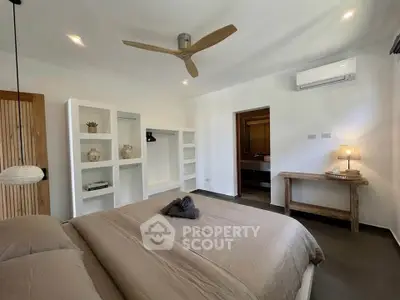 Modern bedroom with neutral tones, ceiling fan, and built-in shelving in a stylish home.