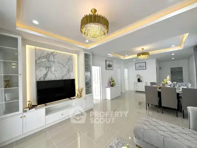 Luxurious open-plan living and dining area with elegant chandeliers and modern decor.