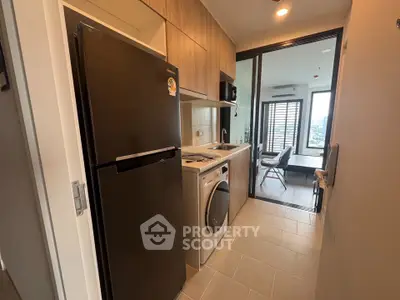 Modern kitchen with sleek appliances and open layout leading to dining area with city view.
