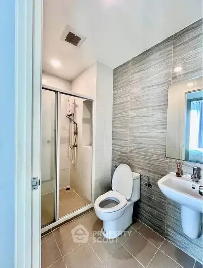 Modern bathroom with sleek shower and contemporary fixtures in a stylish apartment.