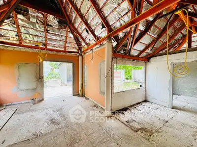 Spacious unfinished interior with exposed beams and large windows, ideal for customization.