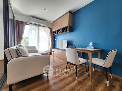 Modern living room with blue accent wall, cozy sofa, and dining area