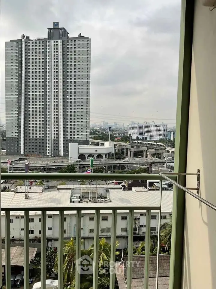 Urban high-rise view from balcony with cityscape and cloudy sky
