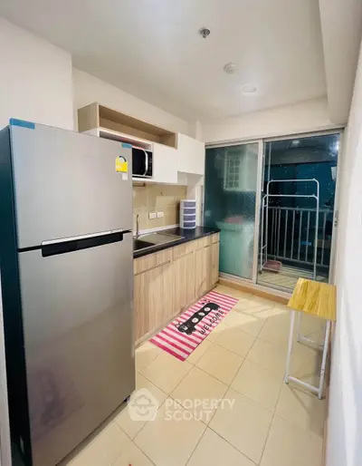 Modern kitchen with sleek appliances and balcony access in a stylish apartment.