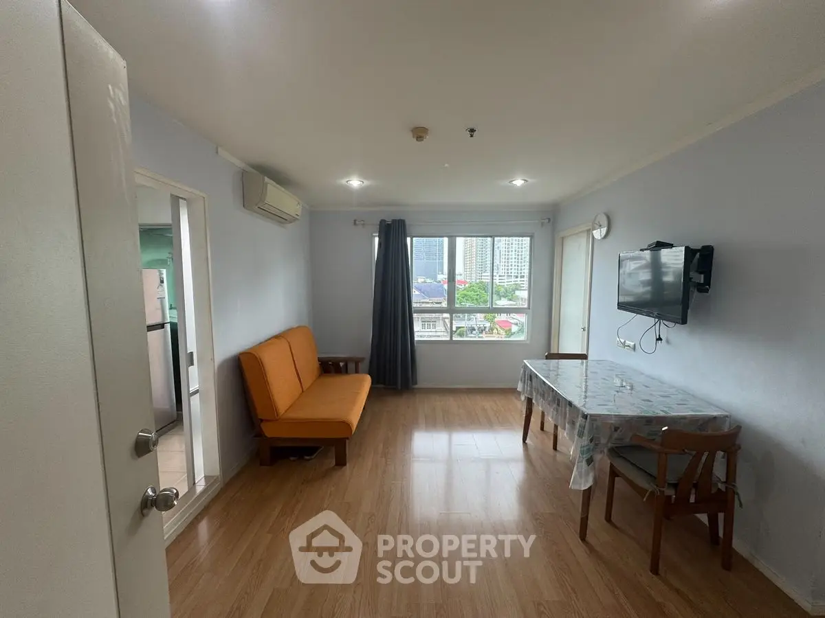 Spacious living room with city view, modern furnishings, and natural light.