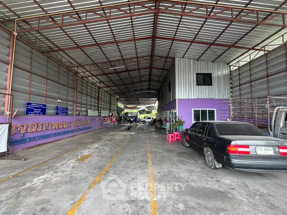 Spacious industrial warehouse with ample parking and high ceilings for versatile use.