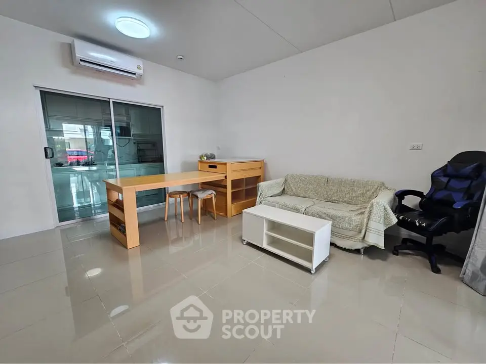 Modern living room with sleek furniture and air conditioning in a bright, minimalist apartment.