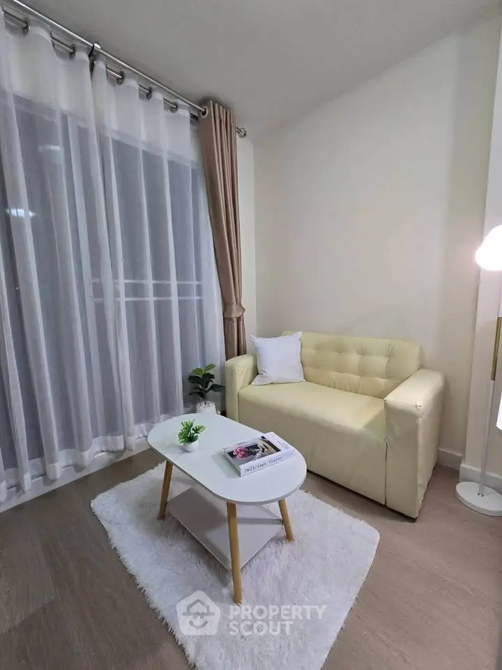 Cozy living room with beige sofa, white rug, and modern decor