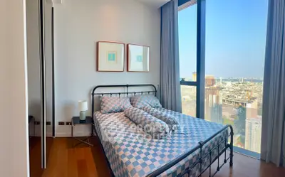 Modern bedroom with stunning city view and stylish decor in high-rise apartment.